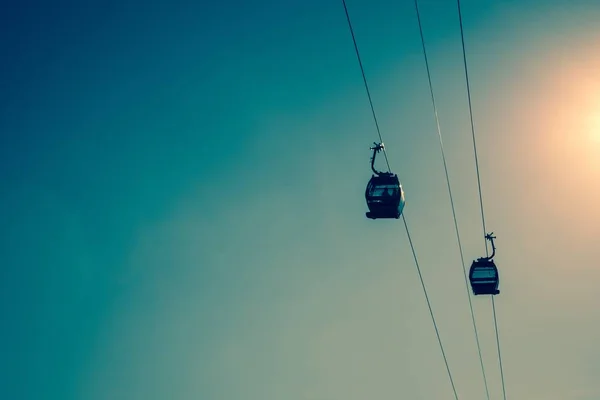 Baixo ângulo tiro de dois teleféricos sob o belo céu brilhante — Fotografia de Stock