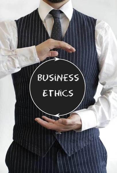 Tiro vertical de um empresário apresentando um círculo com "ética empresarial" escrito dentro — Fotografia de Stock