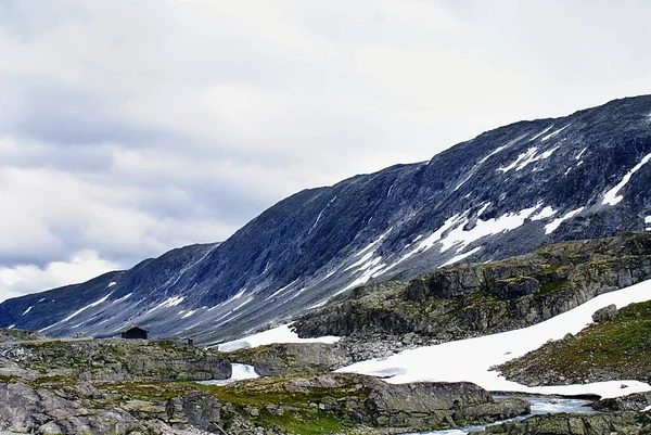 Prachtig landschap met veel rotsachtige bergen onder een bewolkte hemel in Noorwegen — Stockfoto