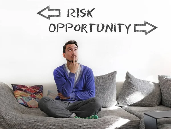 Ein Mann Sitzt Auf Einem Sofa Und Wählt Zwischen Risiken — Stockfoto