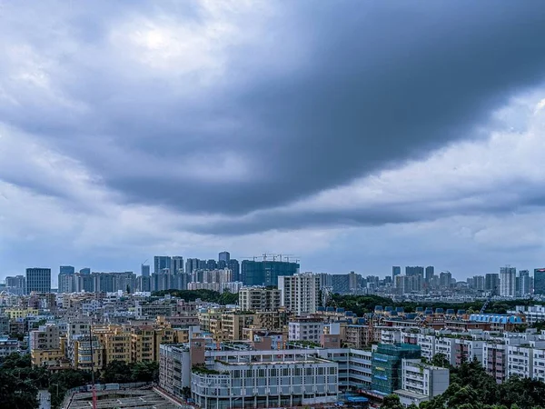 Великолепный снимок современного города и неба, полного темных облаков — стоковое фото