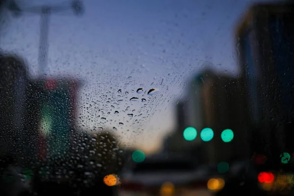 Vista de una ciudad desde la ventana del coche durante la lluvia. — Foto de Stock