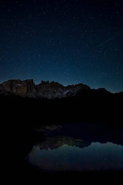 Paisaje relajante del cielo estrellado y acantilados rocosos que reflexionan sobre el lago por la noche. — Foto de Stock