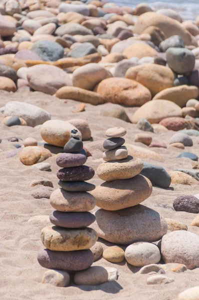 在海滩上互相堆放的漂亮小石头的垂直特写 — 图库照片