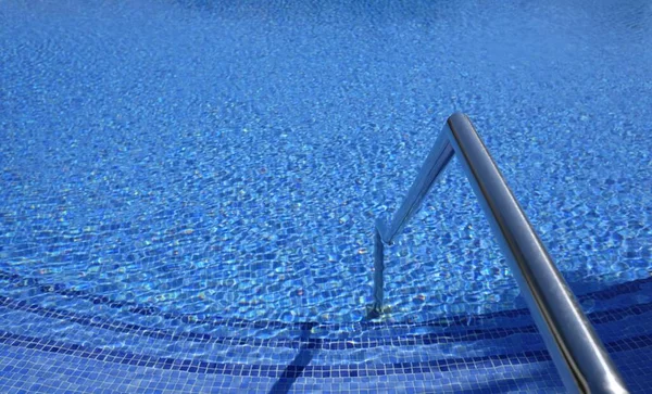 Hullámok a friss tiszta víz felszínén egy szabadtéri medence egy napsütéses napon — Stock Fotó