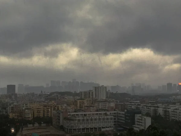 Amplo tiro de uma cidade moderna e movimentada com céu escuro e nuvens — Fotografia de Stock