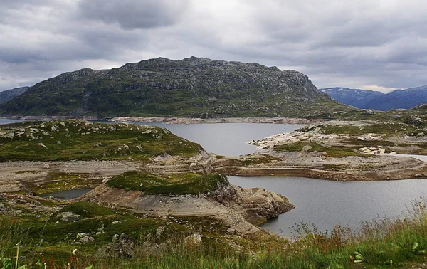 노르웨이의 구름낀 하늘 아래푸른 산들로 둘러싸인 호수가 있는 풍경 — 스톡 사진