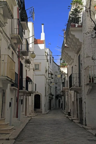 Tiro vertical de un sendero en medio de edificios blancos bajo un cielo azul — Foto de Stock