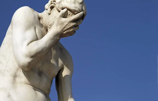 Estátua masculina de pedra com um céu azul no fundo — Fotografia de Stock