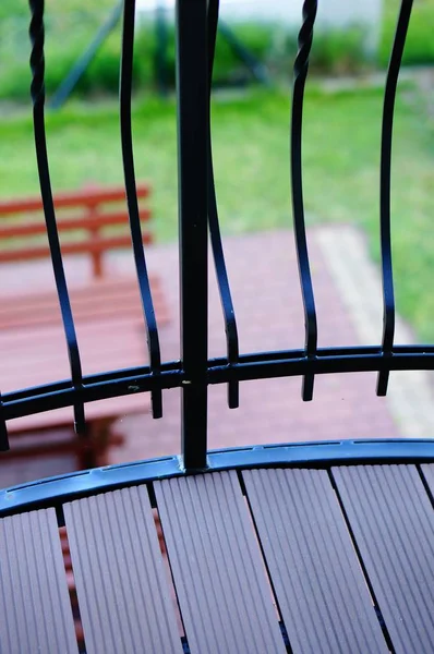 Вертикальний знімок металевого паркану балкона з видом на парк на задньому плані — стокове фото