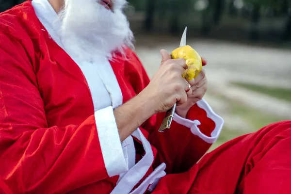 Mikołaj obierający świeże jabłko ostrym nożem na rozmytym tle — Zdjęcie stockowe