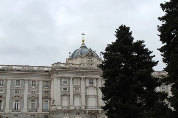 Βασιλικό Παλάτι της Μαδρίτης περιβάλλεται από πράσινο κάτω από ένα συννεφιασμένο ουρανό στη Μαδρίτη στην Ισπανία — Φωτογραφία Αρχείου