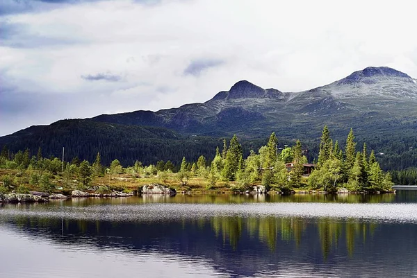 Kleine huizen bij het meer onder de bewolkte hemel in Tuddal Gaustatoppen, Noorwegen — Stockfoto