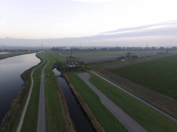 Drone vista di un paesaggio olandese sotto un cielo nuvoloso con nuvole che riflettono sull'acqua durante il giorno — Foto Stock