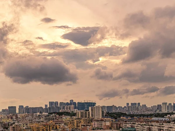 Szerokie ujęcie nowoczesnego miasta z niebem z różowym odcieniem i ciężkimi chmurami podczas zachodu słońca — Zdjęcie stockowe