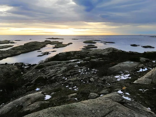 Meer umgeben von Felsen unter wolkenverhangenem Himmel während des Sonnenuntergangs in Rakke in Norwegen — Stockfoto
