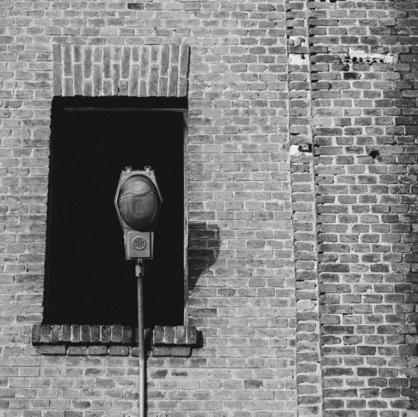Foto en escala gris de una lámpara de calle frente a un edificio antiguo con una ventana rota. — Foto de Stock