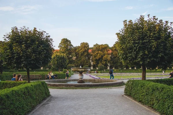 Amplo ângulo de tiro de alguém andando ao lado da fonte de um parque — Fotografia de Stock