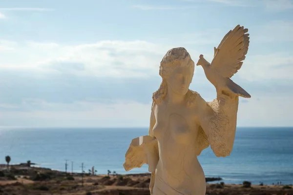 Statue d'une femme avec un oiseau entre les mains pendant le jour — Photo