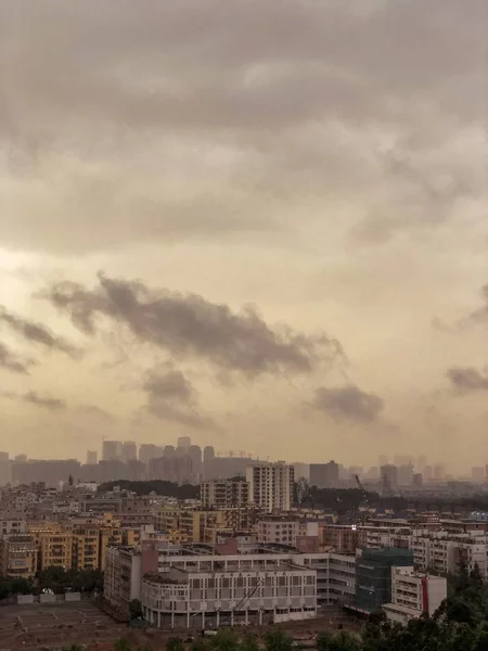 Utsikt över en stad full av byggnader med mörka moln — Stockfoto