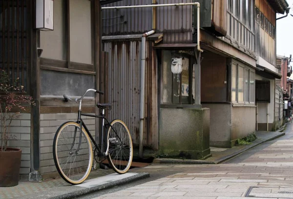 Bicycle leaned against a building on the sidewalk — Stock Photo, Image