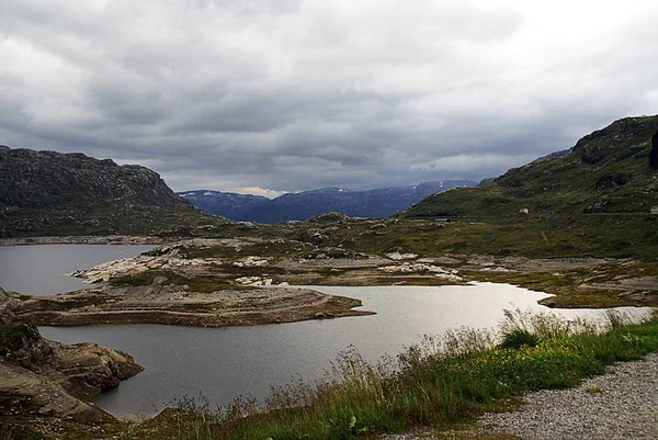Landschap van een landschap met een meer omringd door groene bergen onder een bewolkte hemel in Noorwegen — Stockfoto