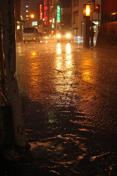 Tiro vertical de coches y edificios de una ciudad por la noche —  Fotos de Stock