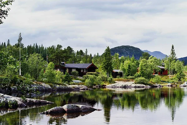 Malé domky u jezera pod zamračenou oblohou v Tuddal Gaustatoppen, Norsko — Stock fotografie