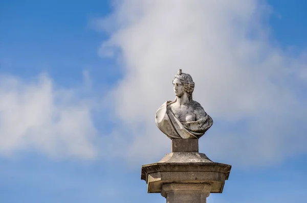 Schöne Aufnahme einer Frauenstatue auf der Säule mit blauem Himmel auf dem Hintergrund — Stockfoto