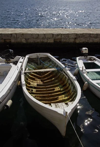 Vertikale Aufnahme von Booten auf dem Wasser hinter einer Mauer — Stockfoto