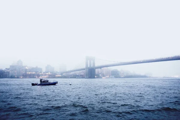 Σκάφος στο νερό κοντά στο καλώδιο-έμεινε γέφυρα κατά τη διάρκεια ομιχλώδη καιρό — Φωτογραφία Αρχείου