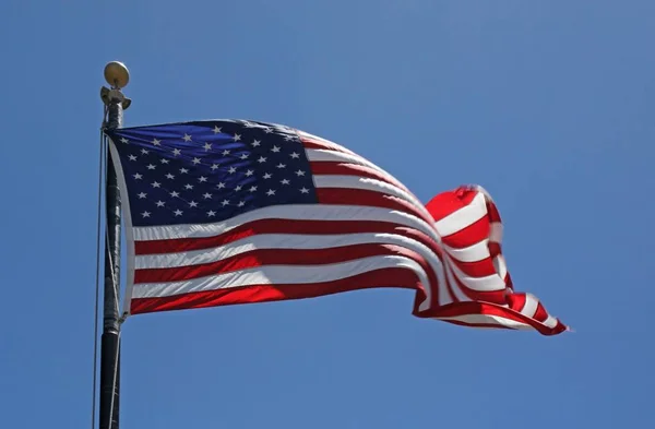 Låg vinkel skott av den amerikanska flaggan under en blå himmel — Stockfoto