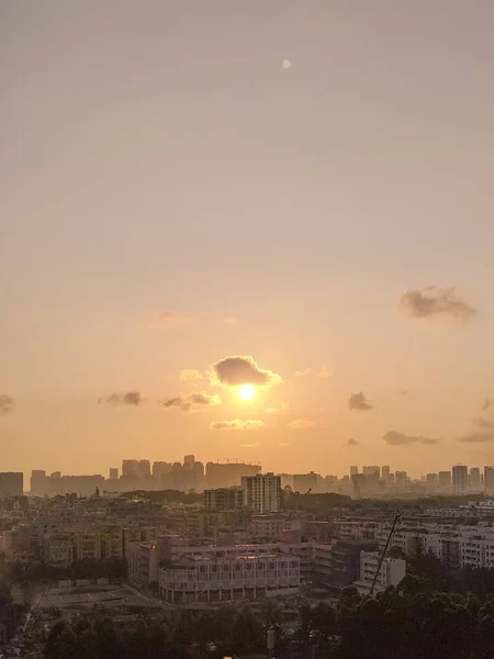 Amplo tiro de uma cidade moderna e movimentada com um céu rosado durante o pôr do sol — Fotografia de Stock