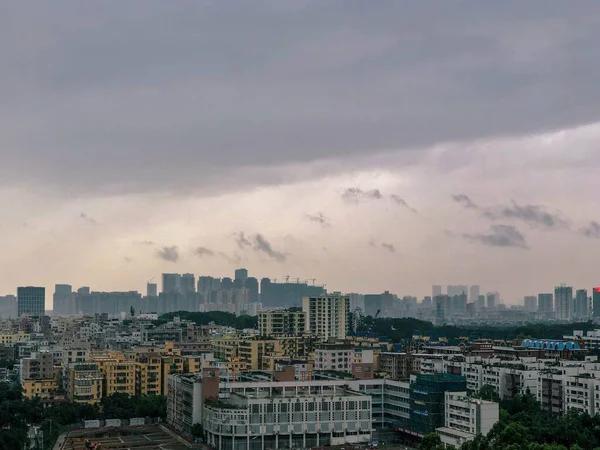 Vue sur une ville moderne et animée avec un ciel gris et des nuages — Photo