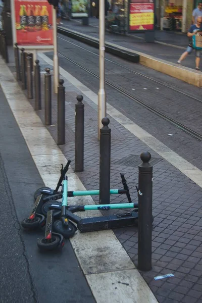 Los scooters de Kick se encuentran junto a varias columnas cortas en la calle. — Foto de Stock