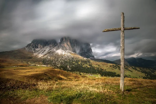 Wooden cross on the hill covered in greenery with the Dolomites in South Tyrol on the background — Stock Photo, Image