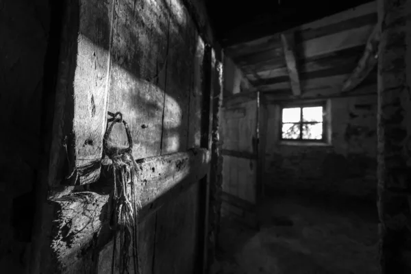 Vue en écailles de gris de l'intérieur d'une grange avec mur et fenêtre abîmés par les intempéries — Photo