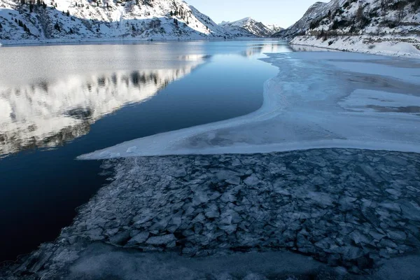 Paysage magnifique d'un lac gelé entouré de hautes montagnes rocheuses enneigées dans les Dolomites — Photo