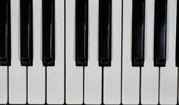Piastrelle bianche e nere di un pianoforte durante il giorno — Foto Stock