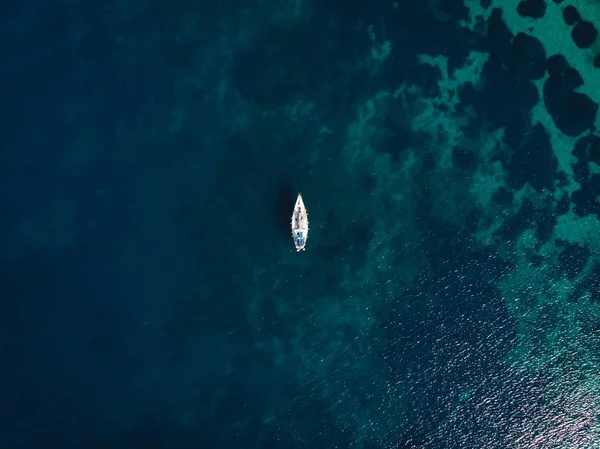 Eenpersoons boot in het midden van helderblauwe zee — Stockfoto