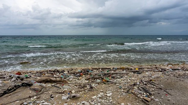 Strand in Utila mit Müll bedeckt, umgeben vom Meer unter wolkenverhangenem Himmel — Stockfoto