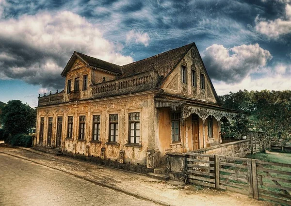 Casa antigua oscura con nubes colgando sobre ella. —  Fotos de Stock