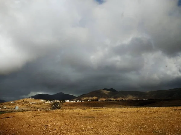 Στιγμιότυπο από το ζοφερό συννεφιασμένο ουρανό και μια αμμώδη γη της Fuerteventura, Ισπανία. — Φωτογραφία Αρχείου