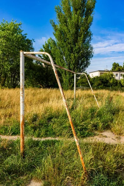 Старые футбольные ворота в парке на фоне деревьев — стоковое фото