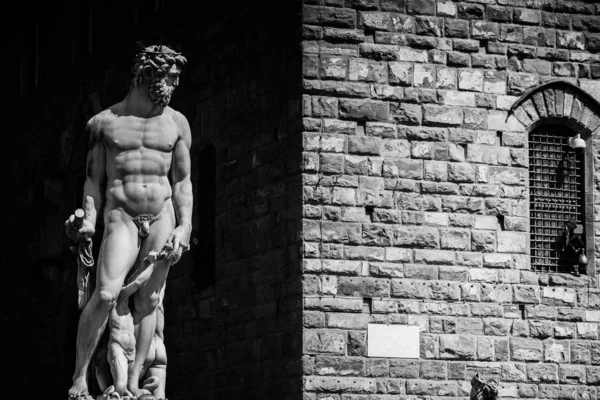 Grayscale skott av en manlig staty nära en byggnad — Stockfoto
