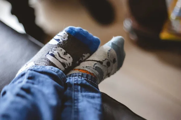 Closeup shot of the legs of a little boy in socks with a blurry background — Stock Photo, Image