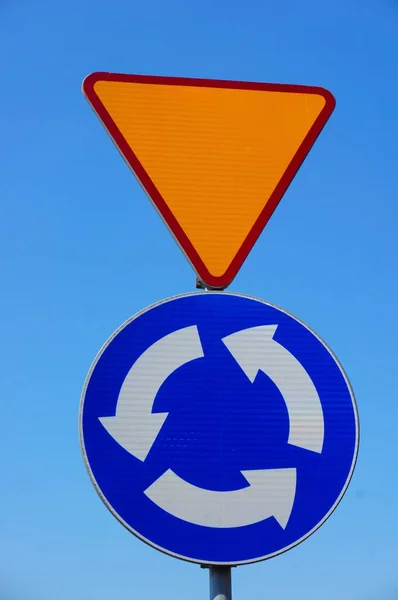 Вертикальный снимок дорожных знаков, указывающих на движение и отдачу автомобиля — стоковое фото