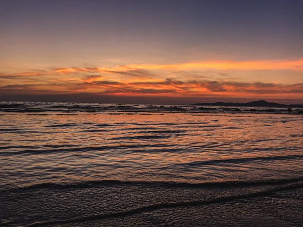 Escenario de puesta de sol en la playa con olas calmantes del océano. — Foto de Stock