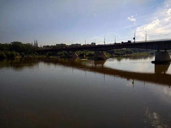 ポーランドのワルシャワで水面を走る石橋のシルエットのショット — ストック写真