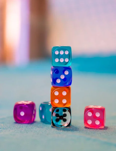 Vertical shot of colorful game dices on a blue table — Stock Photo, Image